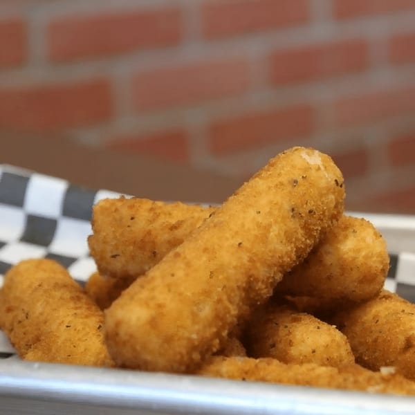 Golden-brown mozzarella sticks from Amelio's Pizza and More, served in a metal basket with checkered paper.
