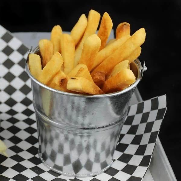 Golden french fries served in a small metal bucket on checkered paper at Amelio's Pizza.