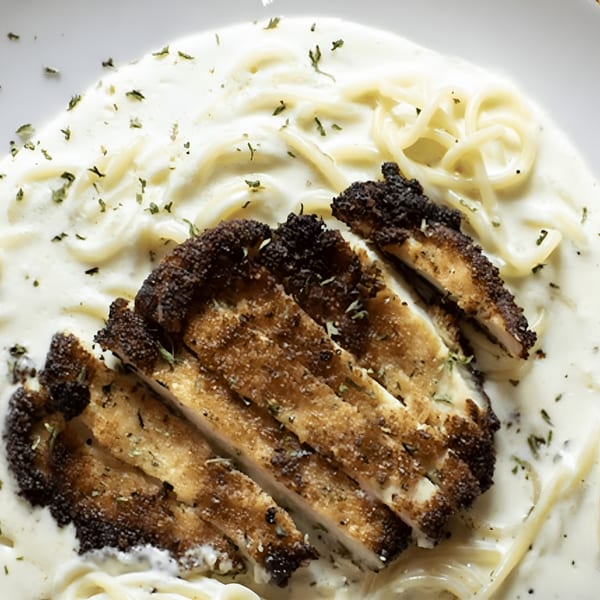 Creamy pasta dish with sliced, breaded chicken cutlets and herbs, served at Amelio's Pizza and More.